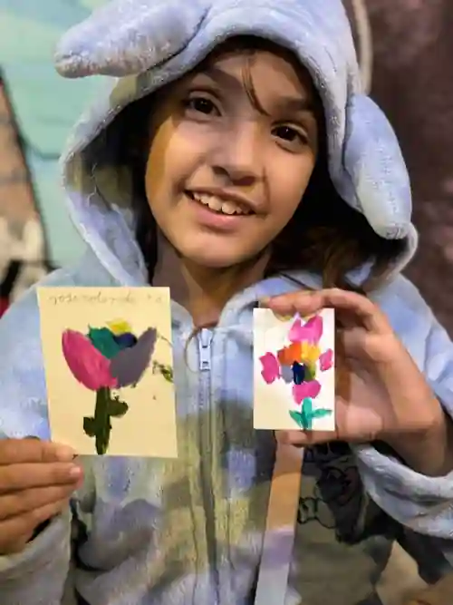 Niña mostrando sus obras